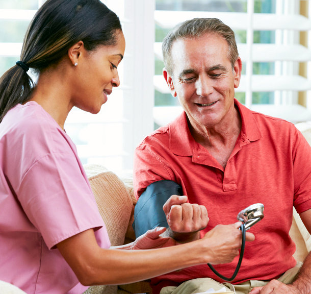 caregiver checking the blood pressure of the elder man