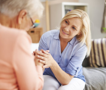 caregiver comforting elder woman